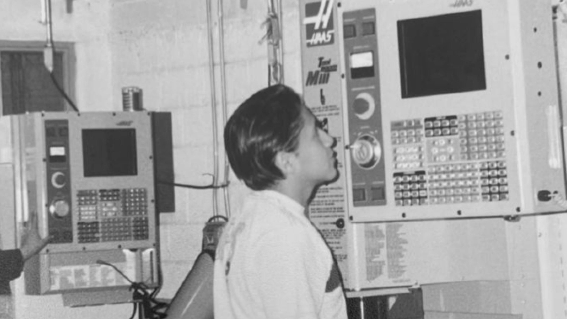 Omar at thirteen looking up at his father's first computer controlled machine